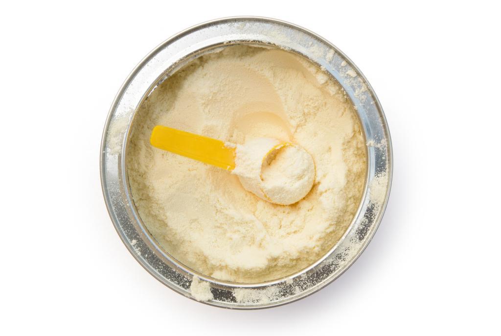 Can of opened powdered milk with a scoop.