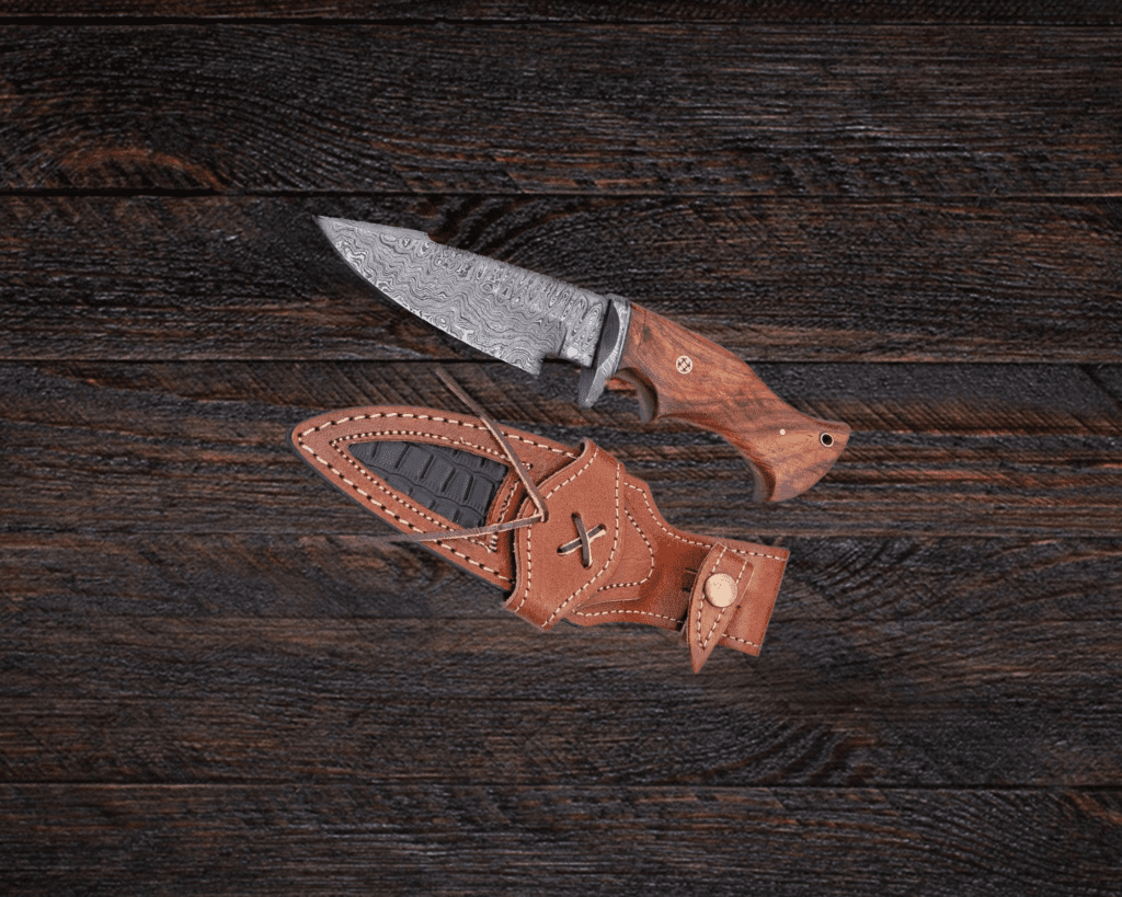Photo of a Damascus bushcraft knife and leather sheath.
