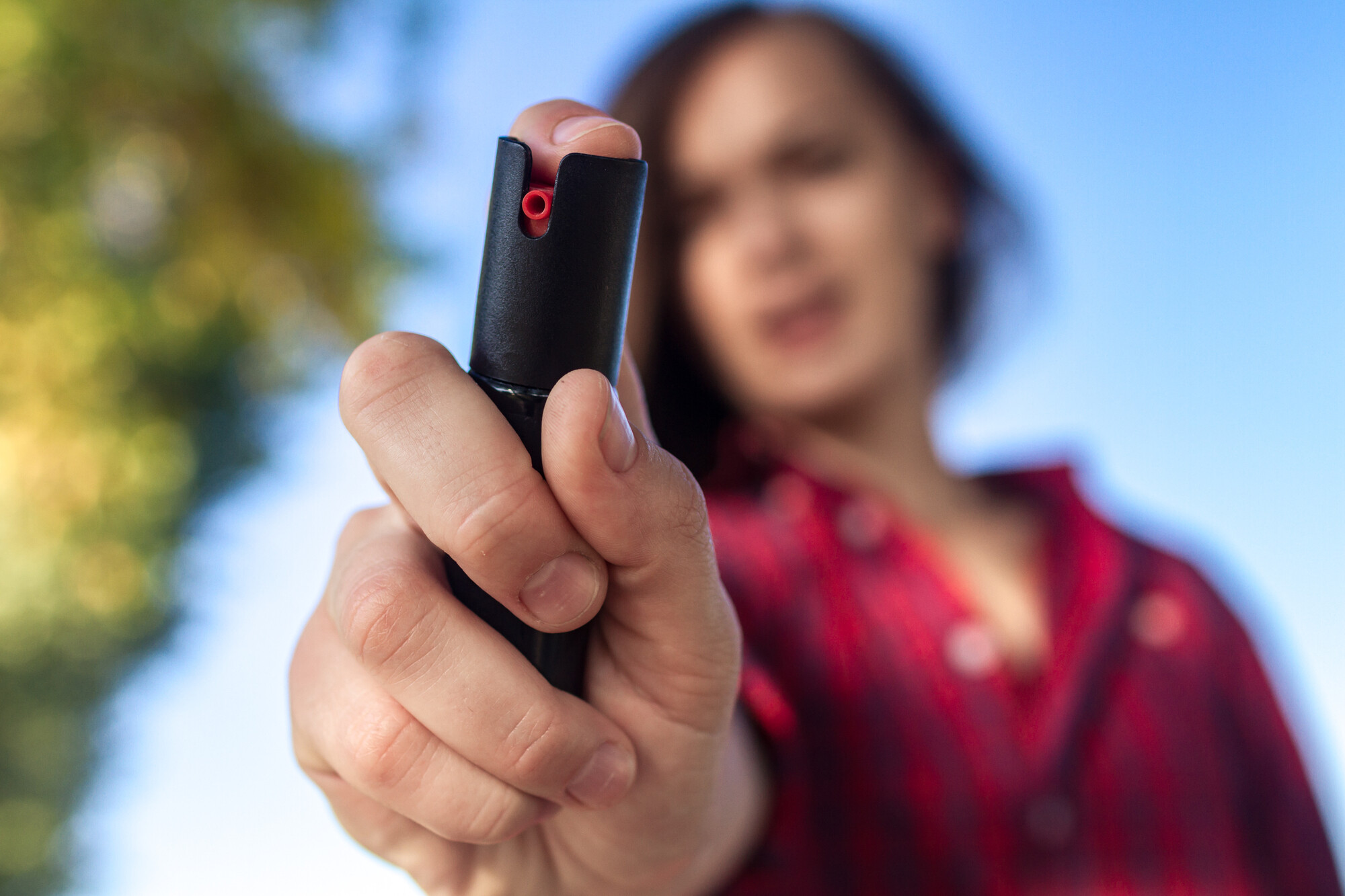 Woman using one of the best self defense keychains with pepper spray.
