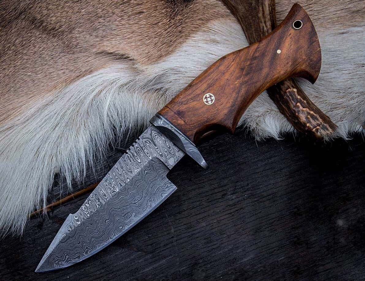 Damascus knife resting on animal fur.